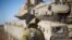 FILE - An Israeli soldier stand by a tank near the border with Syria in the Israeli-controlled Golan Heights, Monday, Nov. 28, 2016. 