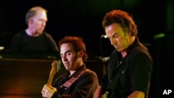 Bruce Springsteen, derecha, y Nils Lofgren tocan la guitarra juntos.