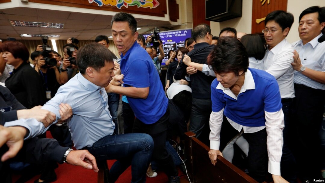Anggota legislatif Partai Demokratik Progresif (DPP) Chao Tien-lin, pergi dan bentrok dengan legislator Kuomintang (KMT) oposisi selama pertemuan anggaran untuk program pembangunan infrastruktur, di Badan Legislatif Yuan di Taipei, Taiwan, 18 Juli 2017.