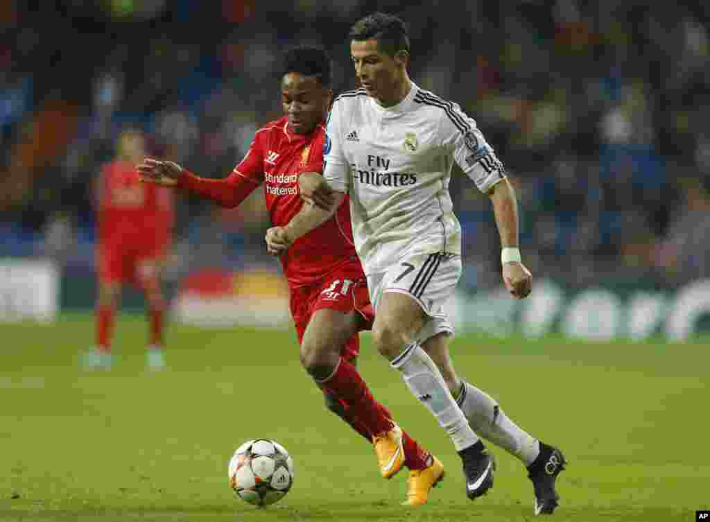 Cristiano Ronaldo du Real Madrid, à droite, se bat pour la balle avec Raheem Sterling de Liverpool lors d&#39;un match de football, Groupe B, de la Ligue des Champions entre le Real Madrid et Liverpool au stade Santiago Bernabeu à Madrid, Espagne, le mardi 4 novembre 2014.