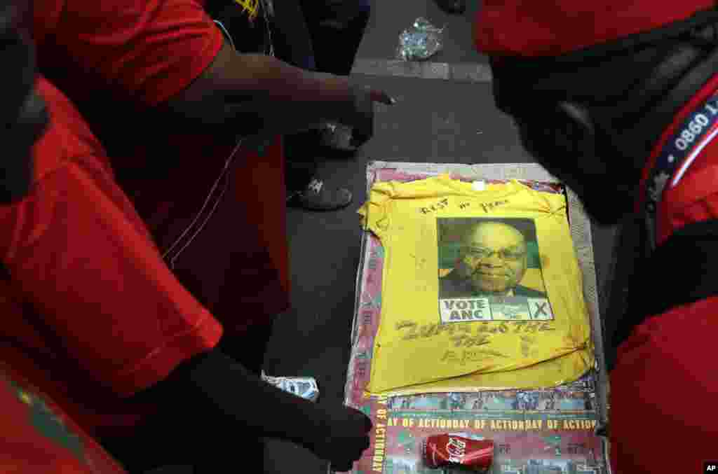 Manifestantes desfilam com caixão com a foto de Zuma.