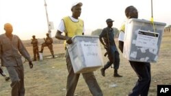 Men carry ballot boxes after elections in South Sudan in 2011. 