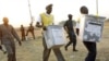 Election officials carry ballot boxes moments after polls closed in 2011 in Juba, in what was then southern Sudan.