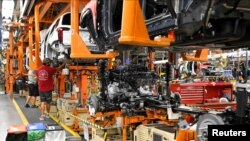 FILE - The engine and drive train are pictured with the body on the assembly line at the General Motors (GM) manufacturing plant in Spring Hill, Tennessee, Aug. 22, 2019.
