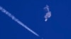 Balon mata-mata China setelah ditembak jatuh, terlihat melayang di atas Samudra Atlantik, tepat di lepas pantai South Carolina, di dekat awan putih jejak pesawat jet tempur AS, Sabtu, 4 Februari 2023.(Chad Fish via AP)