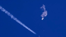 Balon mata-mata China setelah ditembak jatuh, terlihat melayang di atas Samudra Atlantik, tepat di lepas pantai South Carolina, di dekat awan putih jejak pesawat jet tempur AS, Sabtu, 4 Februari 2023.(Chad Fish via AP)