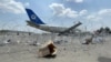 Sebuah pesawat komersial terlihat di balik penghalang di Bandara Internasional Hamid Karzai di Kabul, Afghanistan, 31 Agustus 2021. (Foto: Reuters)