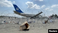 FILE - A commercial airplane is seen behind a barrier at Hamid Karzai International Airport in Kabul, Afghanistan, Aug. 31, 2021. 