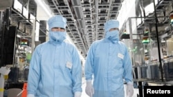 FILE - German Economy Minister Robert Habeck and Foreign Minister Annalena Baerbock wear protective suits during their visit to the semiconductor manufacturer of Infineon Technologies AG in Dresden, Germany, July 13, 2023. 