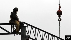 A worker sits atop some ironwork at the construction site of a new store at the Harvard Park Shopping Center in Warrensville Hts., December 7, 2011