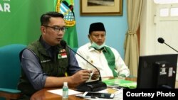 Gubernur Jabar Ridwan Kamil (kiri) dan Wagub Jabar UU Ruzhanul (kanan) saat menggelar pertemuan dengan 27 ketua MUI se-Jabar via video conference terkait fatwa haram mudik dan persiapan Ramadan, Kamis, 9 April 2020. (Foto: Humas Jabar)