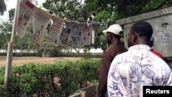 Des Togolais lisent les nouvelles du jour à Lomé, Togo, le 19 mai 2005.