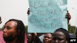 Les parents et les proches des étudiants du Collège fédéral de Kaduna qui ont été enlevés, tiennent des pancartes lors d'une manifestation à Abuja, le 4 mai 2021.