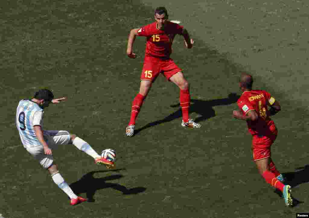 Argentina's Gonzalo Higuain scores past Belgium's Daniel Van Buyten and Vincent Kompany at the Brasilia national stadium in Brasilia, July 5, 2014.