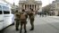 Belgian soldiers stand guard next to one of the memorials to the victims of the recent Brussels attacks, at the Place de la Bourse in Brussels, March, 27, 2016. 