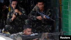 Government soldiers battling Moro National Liberation Front rebels take up positions in downtown Zamboanga city, in southern Philippines, Sept. 11, 2013. 