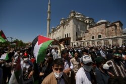 A child holds a Palestinian flag during a rally outside Fatih mosque in Istanbul, May 4, 2021, in support of Palestinians, killed in the recent escalation of violence in Jerusalem and the Gaza Strip.