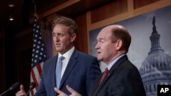 Sen. Jeff Flake, R-Ariz., left, and Sen. Chris Coons, D-Del., talk to reporters after making speeches on the Senate floor calling for a resolution to back the U.S. intelligence community findings that Russia interfered in the 2016 election and calling for other responses to the meddling, on Capitol Hill in Washington, July 19, 2018. 