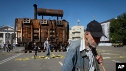 A man passes a burned transformer from a power plant badly damaged in one of Russia's recent missile attacks on energy systems in Kyiv, Ukraine, Sept. 19, 2024. 