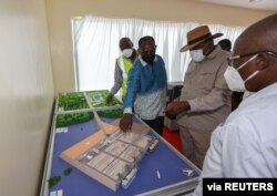 Kenya's President Uhuru Kenyatta and Kenya's Finance Minister Ukur Yatani look at the architectural model of the Chinese-funded Lamu port in Lamu, Kenya, May 20, 2021.