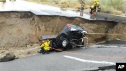 En esta imagen, proporcionada por el Departamento de Bomberos del Condado Riverside, equipos de emergencia trabajan después de que una camioneta quedara atrapada en el derrumbe de un tramo elevado de la Interestatal 10, el domingo 19 de julio de 2015, en Desert Center, California.