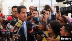 Venezuelan opposition leader Juan Guaido, who many nations have recognized as the country's rightful interim ruler, talks to the media as he arrives to attend a session of Venezuela's National Assembly in Caracas, Venezuela, Sept. 17, 2019. 