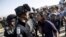A young Jewish settler, right, speaks with an Israeli police officer near buildings slated for demolition by order of Israel's high court, in the West Bank Jewish settlement of Beit El near Ramallah, July 28, 2015.
