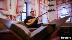 Muzičar Zanin Berbić svira tradicionalni instrument saz, u Sarajevu 20. decembra 2024. (Foto: Reuters/Amel Emrić)