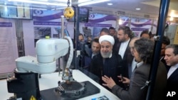  FILE - President Hassan Rouhani listens to explanations of nuclear achievements in Tehran, Iran, April 9, 2018. Iran has broken the limit set on its stockpile of low-enriched uranium by the 2015 nuclear deal, and will raise its enrichment of uranium.