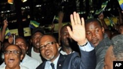 Andre Mba Obame (C) (AMO) greets supporters upon his arrival at the airport Leon Mba in Libreville, 30 Dec 2010