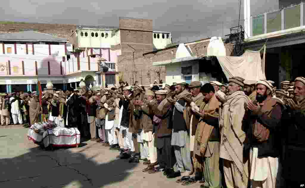 Para kerabat dan simpatisan berdoa dekat jenazah petugas vaksin polio yang tewas dalam ledakan bom di Parachinar, Pakistan (31/1). (AP/Dilawar Hussain)