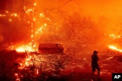 Bruce McDougal prepares to defend his home as the Bond Fire burns though the Silverado community in Orange County, California, Dec. 3, 2020.