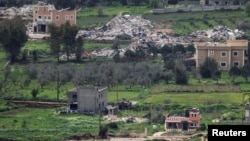 2026년 4월 14일, 이스라엘 북부에서 포착된 레바논 남부 접경 지역의 모습. 파괴된 건물 근처에 이스라엘 군용 차량이 보인다.