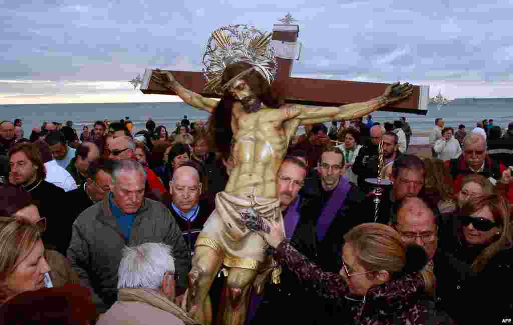 Worshippers surround the icon of the Santisimo Cristo del Salvador brotherhood during a Holy Week procession in Valencia, Spain. (AP)