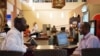 FILE - Men work on their laptops at an internet cafe in Kampala, Nov. 11, 2011.