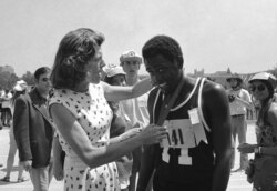 유니스 케네디 슈라이버 여사가 지난 1972년 미국 캘리포니아주 로스엔젤레스에서 열린 국제스페셜올림픽에서 육상경기에서 우승한 아도니스 브라운 선수에게 금메달을 수여하고 있다.