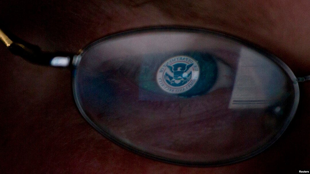 FILE - The logo of the U.S. Department of Homeland Security is reflected in the spectacles of an analyst working in a watch and warning center of a cyber security defense lab in Idaho, Sept. 29, 2011. 