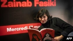 Zainab Fasiki, caricaturiste marocaine et militante des droits des femmes, avec son dernier livre intitulé "Hshouma", dans la ville côtière de Casabalanca, à l'ouest du Maroc, le 17 mars 2021.