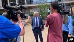 FILE - Defense attorney Earl Gray, center, talks to reporters outside court in downtown Minneapolis after his client, former Minneapolis police Officer Thomas Lane, made his first court appearance in the death of George Floyd, June 4, 2020.