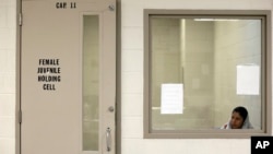 FILE - A juvenile detainee sits in a holding cell at a U.S. Customs and Border Protection processing facility in Brownsville, Texas, June 18, 2014. 