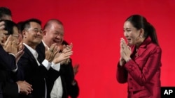 FILE - Pheu Thai Party leader Paetongtarn Shinawatra, right, daughter of Thailand's former Prime Minister Thaksin Shinawatra, offers a traditional greeting known as a "wai" to members of Pheu Thai Party in Bangkok, Thailand, Oct. 27, 2023. 