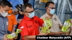 Petugas BNN memperlihatkan paket sabu yang disita dari dua tersangka penyelundup narkoba saat konferensi pers di Banda Aceh pada 13 Oktober 2020. (Foto: AFP/Chaideer Mahyuddin)