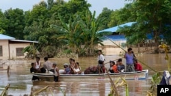 ชาวบ้านขึ้นเรือเดินทางบนน้ำท่วมถนนในกรุงเนปิดอว์ เมียนมา 17 ก.ย. 2024 (AP Photo/Aung Shine Oo)