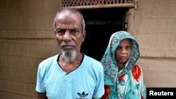 Abdul Suban, petani, dan istrinya berpose di luar rumah mereka di Desa Nellie, distrik Morigaon, di barat daya negara bagian Assam, India, 25 Juli 2018.