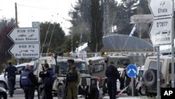 Israeli soldiers and police officers examine the scene of an attack in the Gush Etzion junction in the West Bank, March 18, 2016.