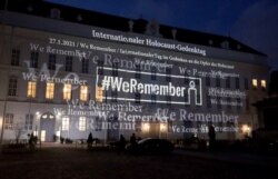The words '#WeRemember' are displayed at the facade of the Austrian Parliament at the Hofburg palace in support of the campaign for the International Holocaust Remembrance Day in Vienna, Jan. 27, 2021.