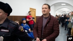 Former Russian police officer Igor Lyakhovets is escorted to a courtroom in Moscow, Jan. 30, 2020.