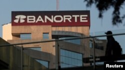 FILE - A man walks past the headquarters of Banorte bank in Monterrey, Mexico, Dec. 5, 2017.