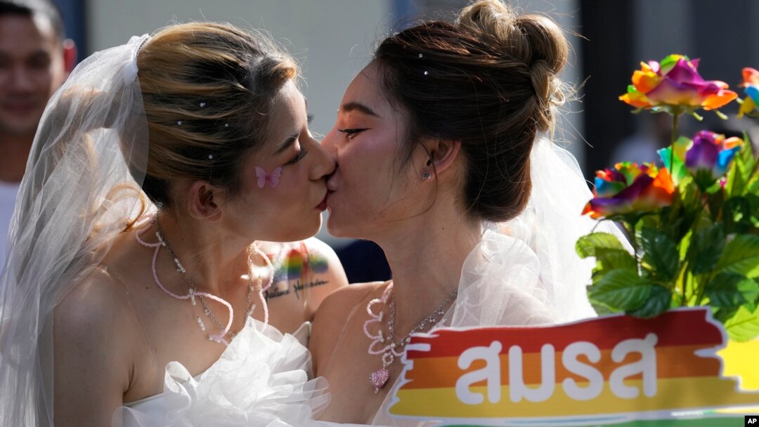 FILE - Women in wedding gowns kiss while holding a poster in support of marriage equality, during a Pride Parade in Bangkok, Thailand, June 4, 2023. A marriage equality bill sailed through both Thailand's House of Representatives and the Senate in April and June respectively.