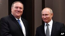 Russian President Vladimir Putin, right, and U.S. Secretary of State Mike Pompeo, pose for a photo before their talks in the Black Sea resort city of Sochi, southern Russia, May 14, 2019. 